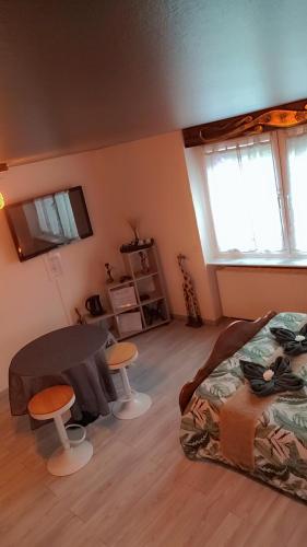 a bedroom with a bed and a table and two stools at Gîtes & Chambres d'hôtes Villa La Lorraine in Folkling