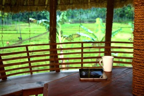 a laptop sitting on a wooden table on a porch at Minash Villa By Mirth, Wayanad, Kerala in Wayanad