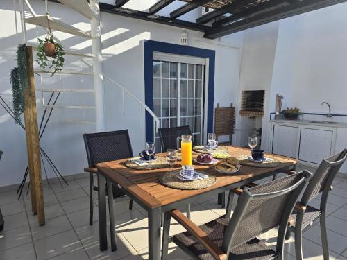 a dining room with a wooden table and chairs at Ria's Birds in Cabanas de Tavira