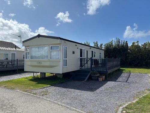 a tiny house sitting on top of a gravel driveway at Seaside Escape 2-Bed Caravan at Seven Bays Park in Saint Merryn