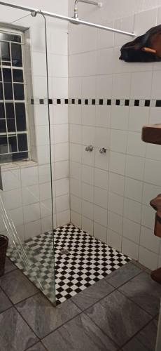 a shower with a black and white checkered floor at Inkonka Game farm in Uitsig