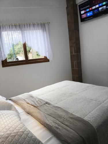 una camera da letto con un letto e una finestra di Casa Torta 01 a Gramado