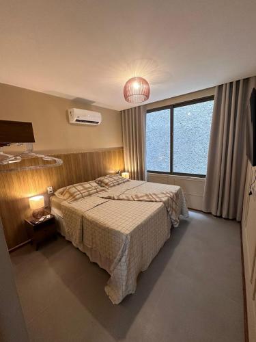 a bedroom with a bed and a large window at Apartamento Luxo em Japaratinga in Japaratinga