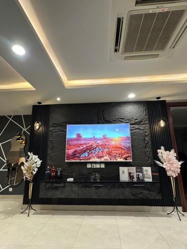 a large flat screen tv on a black wall at Gold Crest Apartments Luxurious in Lahore