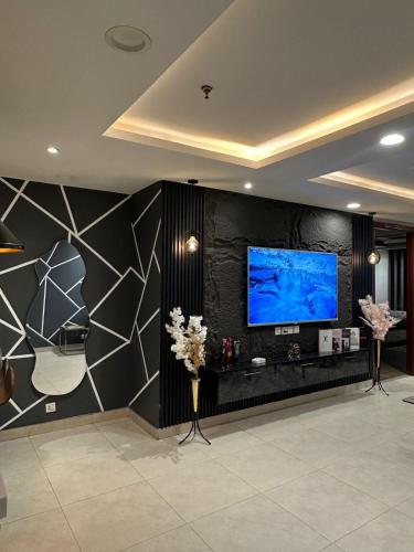 a living room with a large screen tv on a wall at Gold Crest Apartments Luxurious in Lahore