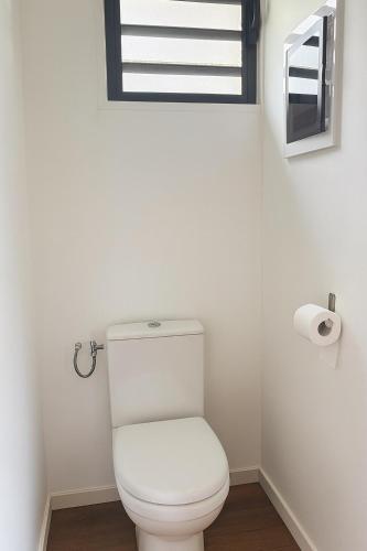 aseo blanco en un baño con ventana en Fisherman Hut, en Le Gosier