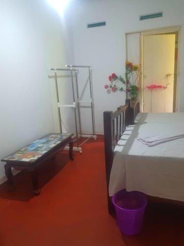 a room with a bed and a bench and a door at Maithree International Meditation Center in Matara