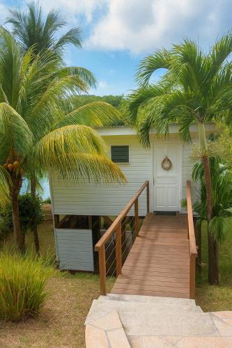 una casa con una pasarela de madera que conduce a un garaje en Fisherman Hut, en Le Gosier