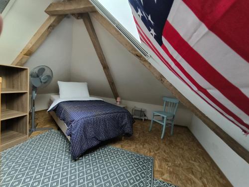 a room with a bed with a american flag at GITE A THEME D-DAY - situé à 15mn d'Omaha Beach - Animaux OK - Terrain clos - Aucuns voisins in Cartigny-lʼÉpinay