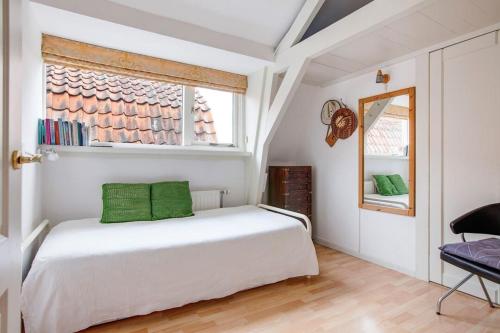 a bedroom with a white bed and a window at Family rooms in central, historic Gouda in Gouda