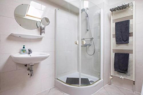 a white bathroom with a shower and a sink at Family rooms in central, historic Gouda in Gouda