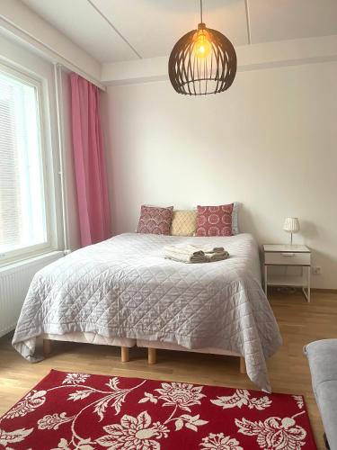 1 dormitorio con cama y alfombra roja en Scandinavian Studio Great Location, en Vantaa