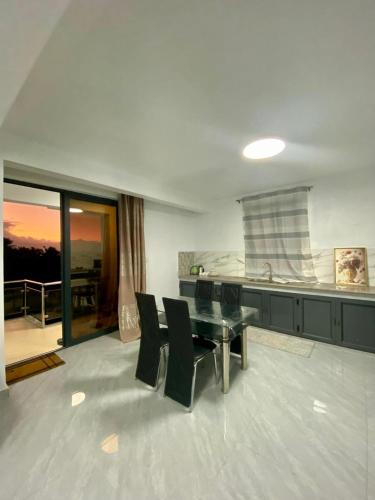 a dining room with a glass table and black chairs at Good Vibes Pereybere in Grand Baie