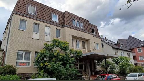 un grand bâtiment en briques avec des voitures garées devant lui dans l'établissement Lessinghof, à Brunswick