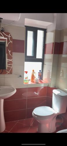 a bathroom with a white toilet and a sink at Sunny Flat Kamez Tirana Nearby in Kamëz