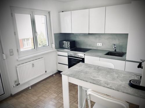 a kitchen with white cabinets and a counter top at City, See, Ruhe - Bodensee Apartment in Lochau