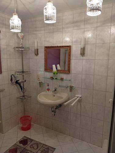 a bathroom with a sink and a mirror at Ruhige Oase mit Pool & Garten Ferienwohnung Niggl in Untergriesbach