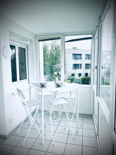 a white table and chairs in a room with a window at City, See, Ruhe - Bodensee Apartment in Lochau
