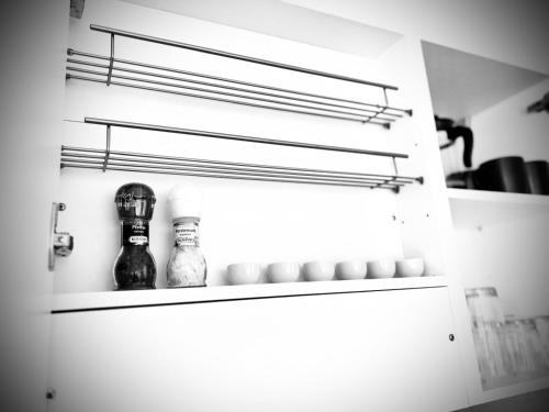 a kitchen cabinet with a shelf with bottles on it at City, See, Ruhe - Bodensee Apartment in Lochau