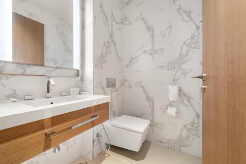 a white bathroom with a toilet and a sink at Address Residence Dubai Opera 25 by Luxstay Holiday Homes in Dubai