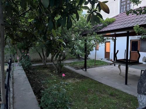 a garden outside a house with trees and a sidewalk at Student Dormitory WSEC in Baku