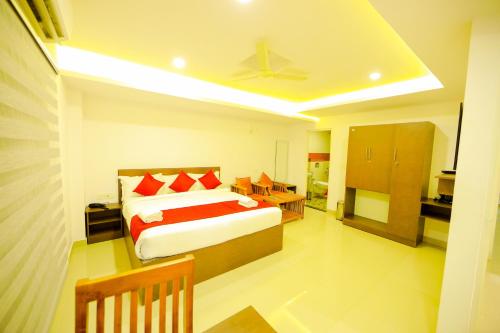 a bedroom with a bed with red pillows at Airport Avenue Plaza in Nedumbassery