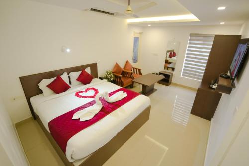 a bedroom with a bed with two slippers on it at Airport Avenue Plaza in Nedumbassery