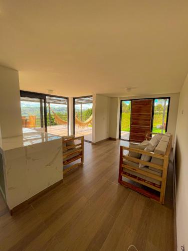 a living room with wooden floors and large windows at Casa campestre guarne in Guarne