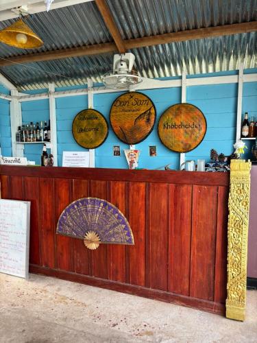 a bar with umbrellas hanging on the wall at Don Som Riverside Guesthouse in Don Som