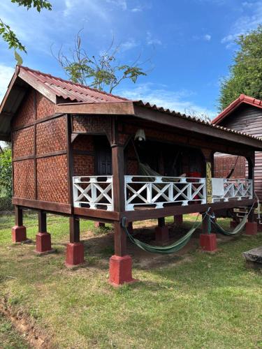 a small house with a porch on the grass at Don Som Riverside Guesthouse in Don Som