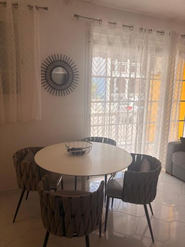 a dining room with a table and chairs and a mirror at In Front of Anse Souffleur in Port-Louis