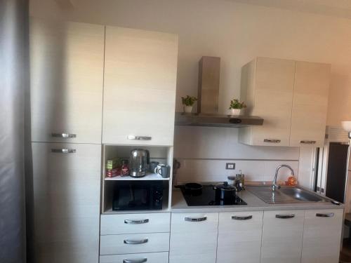 a small kitchen with white cabinets and a sink at Casa Mole, Roma in Marino