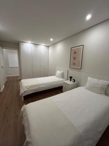two beds in a room with white walls at The Place to Stay ! in Póvoa de Santa Iria