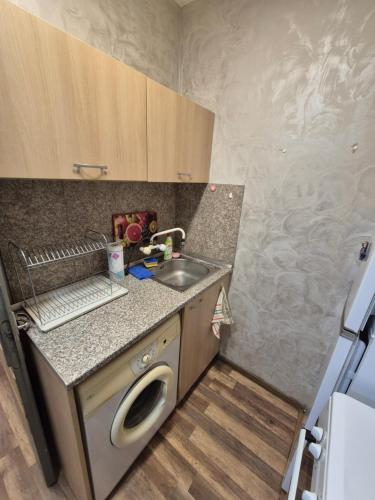 a small kitchen with a sink and a dishwasher at Mladost stay apartment in Sofia