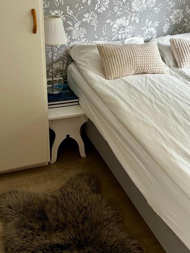 a bedroom with a bed and a table with a lamp at Cozy room surrounded by nature in Falun