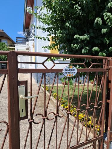 a iron gate with a sign on it at Igali Varázs Apartman 150 méter a fürdőtől in Igal