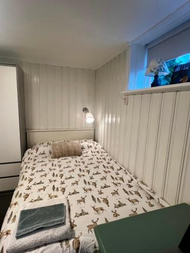 a bedroom with a bed with a blanket with animals on it at Cozy room surrounded by nature in Falun