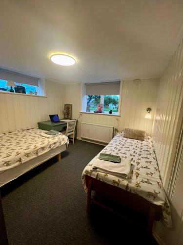 a room with two beds and a desk in it at Cozy room surrounded by nature in Falun