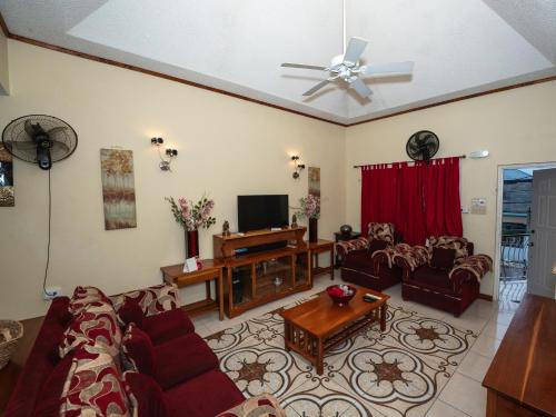 a living room with a couch and a tv at The Residence Portmore Apartments in Portmore