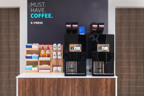 a coffee shop with a coffee machine on a counter at Holiday Inn Express & Suites Buford - Mall of Georgia by IHG in Buford