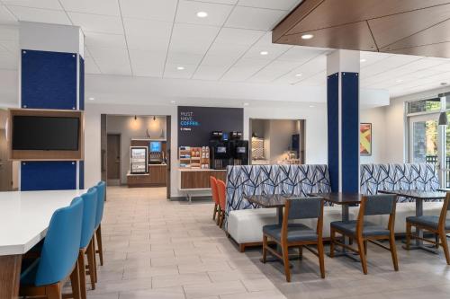 a dining room with tables and chairs in a restaurant at Holiday Inn Express & Suites Buford - Mall of Georgia by IHG in Buford