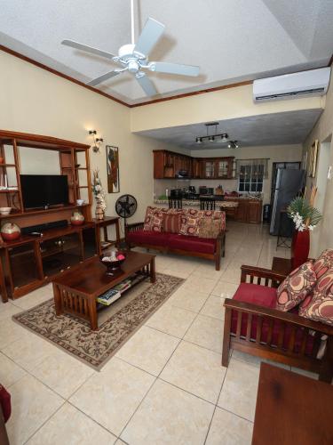 a living room with a couch and a tv at The Residence Portmore Apartments in Portmore