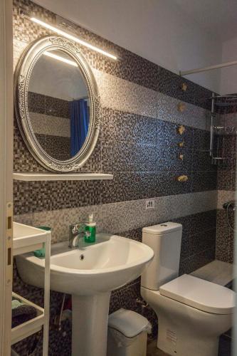 a bathroom with a sink and a toilet and a mirror at Argo Luxury House in Volos