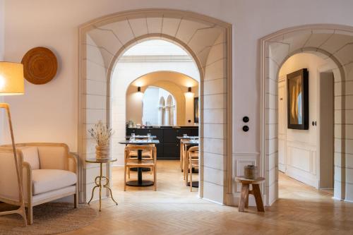 een woonkamer met een boog en een eetkamer bij LA SALAMANDRE - Chambres d'hôtes - Hôtel particulier XVIème - Centre historique - Orléans in Orléans