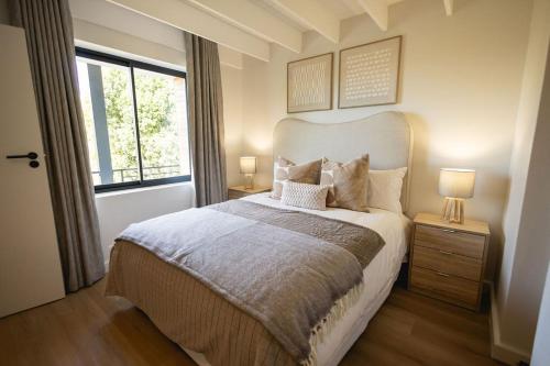 a bedroom with a large bed and a window at Aurora Valley Escape Apartment 9 in Hermanus