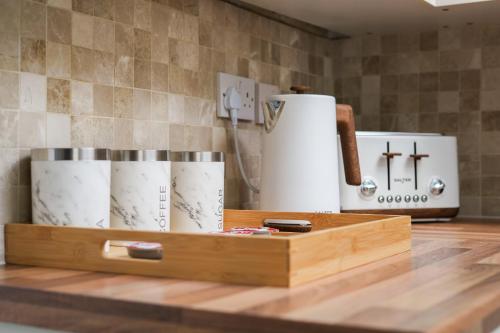 ein Holztablett mit Tassen auf einer Theke in der Unterkunft The cottage near the castle in Conisbrough