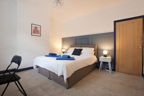 ein Schlafzimmer mit einem großen Bett mit blauen Kissen darauf in der Unterkunft The cottage near the castle in Conisbrough