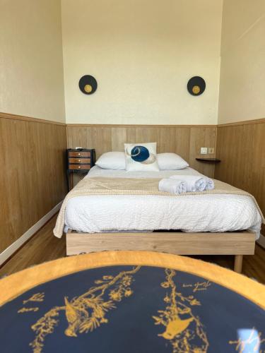 a bedroom with a bed with a blue pillow on it at Hôtel Les Quais in Cherbourg en Cotentin