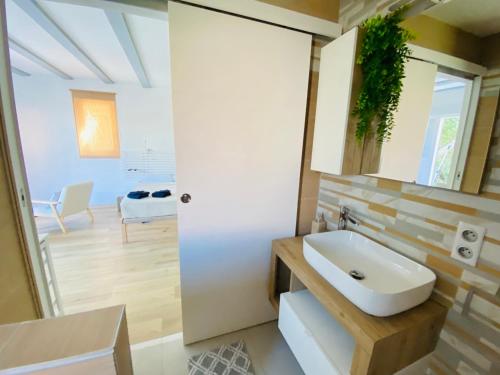 a bathroom with a white sink and a room at Studio Cosy, Rénové, Ecrin de calme & confort in Céret