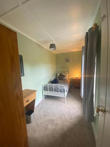 a small bedroom with a bed and a desk at Foxs Farmhouse in Ballinrobe